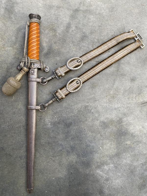 A RARE EARLY ARMY DAGGER WITH SLANT GRIP . PERSONALISED WITH ORIGINAL KNOT AND HANGERS.